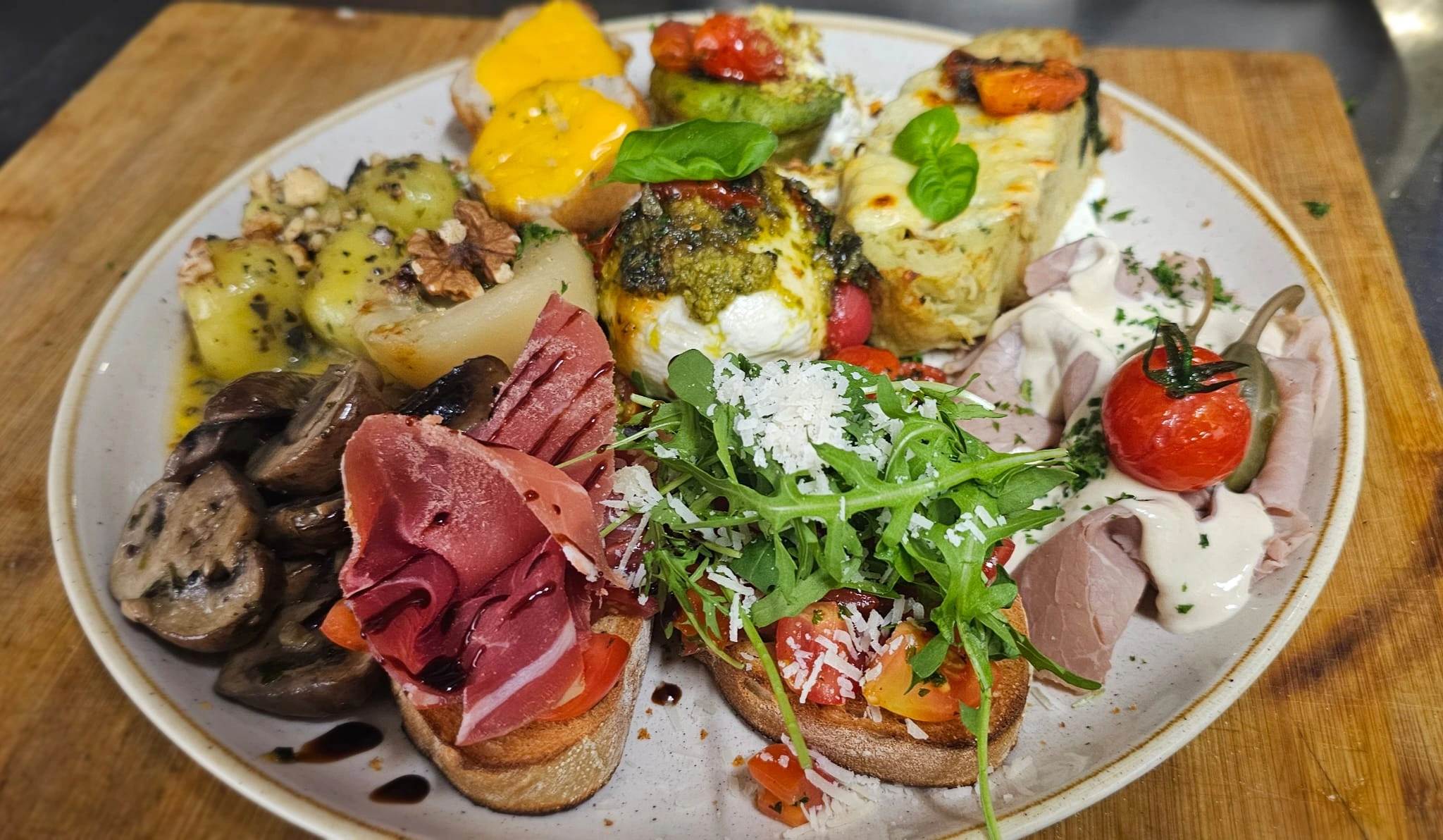 Italienische Antipasti mit Bruschetta, Gemüse und Rucola
